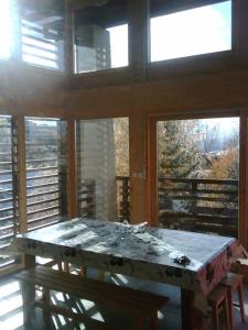 a room with a table in a room with windows at LA PLAGNE MONTALBERT Chalet - fitness - wifi 