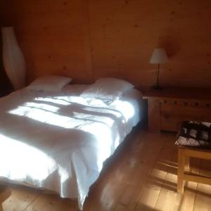 a bedroom with a bed with white sheets and a table at LA PLAGNE MONTALBERT Chalet - fitness - wifi in Montgésin