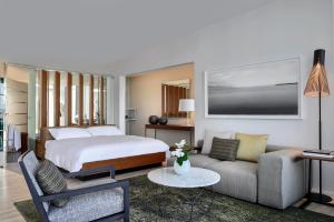 um quarto de hotel com uma cama e um sofá em Hotel Palafitte em Neuchâtel