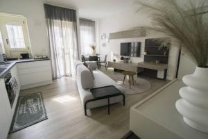 a living room with a white couch and a table at 2 Bed Apartment Sleeps 4 - En-Suite Bath -Tv -WiFi in Asti +9 photos