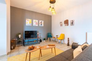 a living room with a couch and a tv at Jason City Escape - Cozy Urban Gem in Kalamata