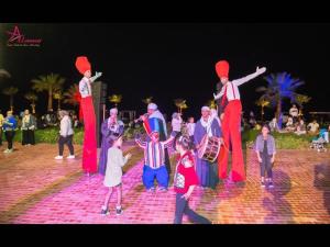 a group of people standing around a group of people dressed in costumes at Porto Said Resort Rentals no070 in El-Garâb`a