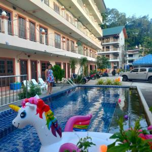 a pool with a unicorn toy next to a building at Pailin Hill Hotel Patong in Patong Beach