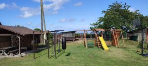 a park with a playground with a slide at Kaltenes Liepziedi in Roja