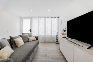 ein Wohnzimmer mit einem Sofa und einem Flachbild-TV in der Unterkunft Salitre in Tejina