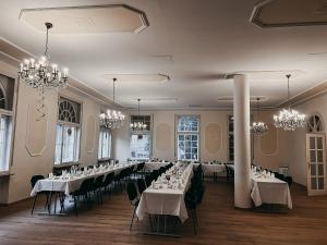 un salón de banquetes con mesas y sillas blancas y lámparas de araña en Hotel Bayerischer Hof en Bad Kissingen