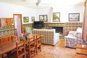 a living room with a table and a fireplace at Casa Rural La Fresneda in Ubrique