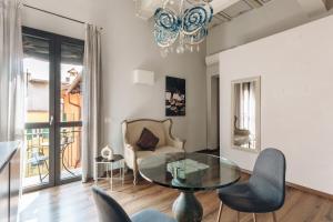 a living room with a glass table and chairs at Opera Residence in Bologna