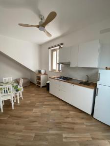 cocina con armarios blancos y ventilador de techo en Casa Gina e Pietro, en Ustica