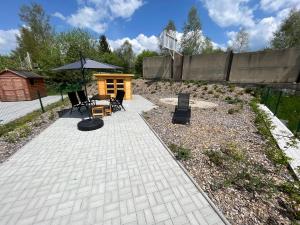 patio ze stołem, krzesłami i parasolem w obiekcie Apartmán Mija w mieście Frymburk