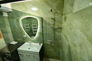 a bathroom with a sink and a shower and a mirror at FLH - The Lake Home - Apt 33 in Sibiu +22 photos