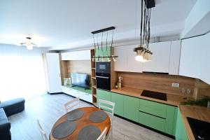 a kitchen with green cabinets and a wooden table at FLH - The Lake Home - Apt 33 in Sibiu