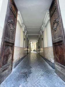 um corredor vazio com duas grandes portas de madeira em Santa House em Nápoles