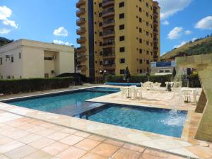 a swimming pool with a fountain and some buildings at Hotel CasaBlanca in Águas de Lindóia +28 photos