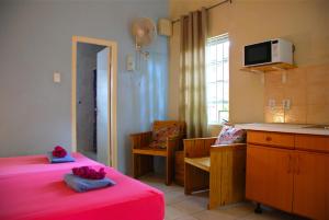 a room with two beds and a table and a kitchen at Caribbean Flower Apartments in Willemstad