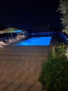 una piscina notturna con piscina blu di TA DIDYMAKIA APARTMENTS. ad Argostoli