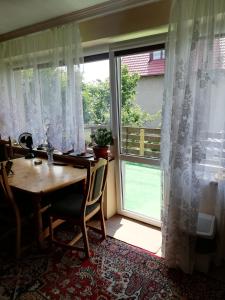 a dining room with a table and a large window at U Sowy in Kołobrzeg