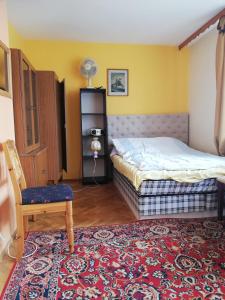 a bedroom with a bed and a chair and a rug at U Sowy in Kołobrzeg