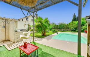 een patio met een rode tafel naast een zwembad bij Amazing Home In Le Pontet With Jacuzzi in Le Pontet