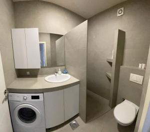 a bathroom with a washing machine and a sink at Plis Apartment II in Pristina