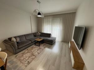 a living room with a couch and a tv at Plis Apartment II in Pristina