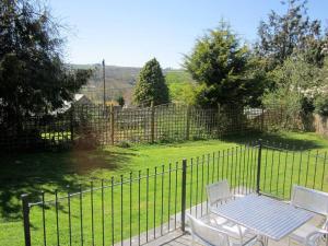 two chairs and a table in front of a fence at Mount Barn in Newcastle Emlyn