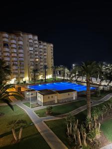 uma grande piscina com iluminação azul em frente a um edifício em Apartamento BuenasVistas em Algarrobo-Costa