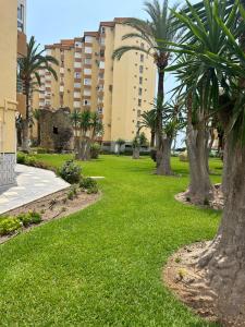 a park with palm trees and a building at Apartamento BuenasVistas in Algarrobo-Costa