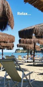 een strand met stoelen en rieten parasols en de oceaan bij Loving Hearts in Ortona