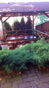 un banco de madera sentado bajo un cenador de madera en Casa Dora en Sovata