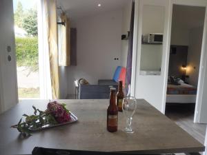 einen Tisch mit zwei Flaschen Wein und einem Glas in der Unterkunft Camping de Trezulien in Douarnenez