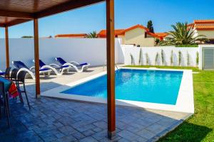 une piscine dans une cour avec des chaises et une maison dans l'établissement Villa Opal, à Cala'n Bosch