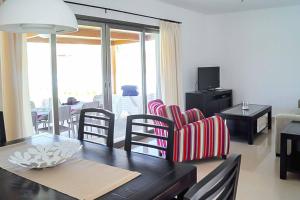 un salon avec une table et des chaises et un salon dans l'établissement Villa Opal, à Cala'n Bosch