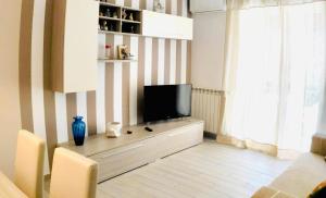 una sala de estar con TV de pantalla plana en una cómoda en Venezia House, en Ladispoli