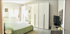 1 dormitorio con 1 cama y TV de pantalla plana en Venezia House, en Ladispoli