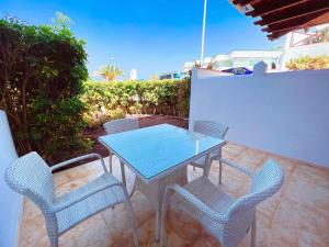 einen Glastisch und Stühle auf einer Terrasse in der Unterkunft First line apartment in El Beril Playa del Duque PD1 in Adeje