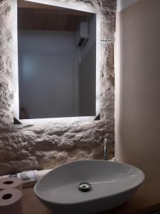 La salle de bains est pourvue d'un lavabo blanc et d'un miroir. dans l'établissement Casina a Porta Sant'Angelo, à Pérouse