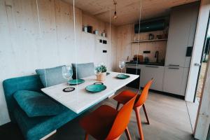 a living room with a green couch and a table and chairs at TinyHouse Rumcajs in Malšín