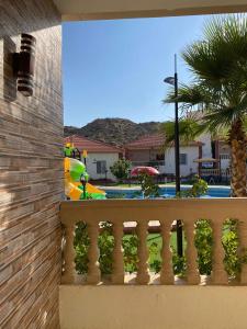 a balcony with a view of a pool and a palm tree at منتجع الجزيرة الخضراء in Al Hada +5 photos