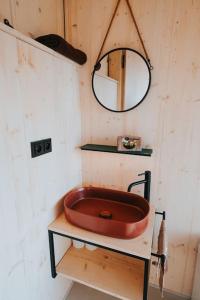 a bathroom with a red sink and a mirror at TinyHouse Rumcajs in Malšín