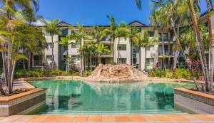 uma piscina com um escorrega em frente a um edifício em Currumbin Sands On The Beach em Gold Coast