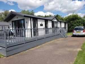 a house with a car parked in front of it at Pebble Lodge in Tydd Saint Giles