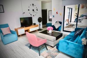 ein Wohnzimmer mit blauen und rosa Möbeln und einem TV in der Unterkunft FINCA LAS MARÍAS 2 in Vergara
