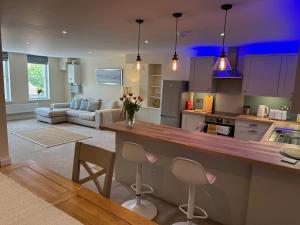 a kitchen and living room with a counter and chairs at Executive Barchester House Apartment in Salisbury