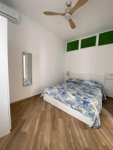 - une chambre avec un lit et un ventilateur de plafond dans l'établissement Casa Gina e Pietro, à Ustica