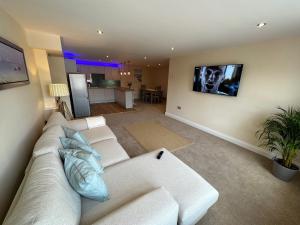 sala de estar con sofá blanco y cocina en Executive Barchester House Apartment, en Salisbury