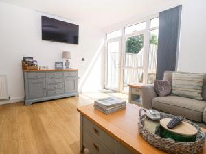 a living room with a couch and a table at 3 Pensyflog Barns in Porthmadog