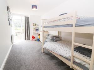 a bedroom with two bunk beds in a room at 3 Pensyflog Barns in Porthmadog