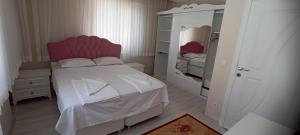 ein kleines Schlafzimmer mit einem Bett und einem Spiegel in der Unterkunft SOYLU Suites in Trabzon