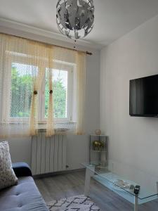 a living room with a blue couch and a tv at Kuća za odmor Viktoria in Opatija